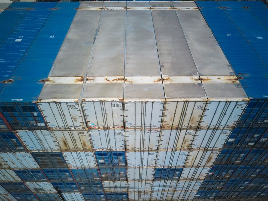 High angle shot of multiple stacked shipping containers showcasing global logistics and trade.